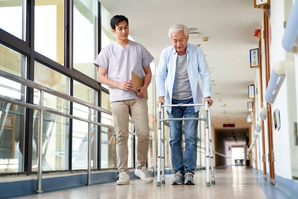 nurse helps man with walker at a SNF