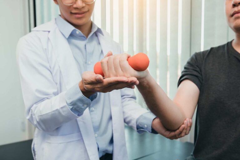 patient uses light hand weights in physical therapy for arm pain