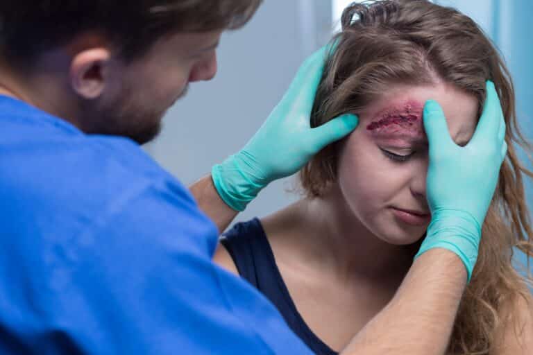 A doctor uses open wound care to treat a head wound