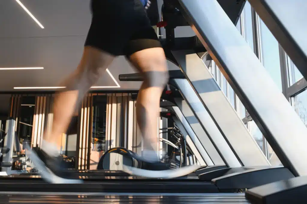 a man's feet run on a treadmill during his cardiac rehab physical therapy